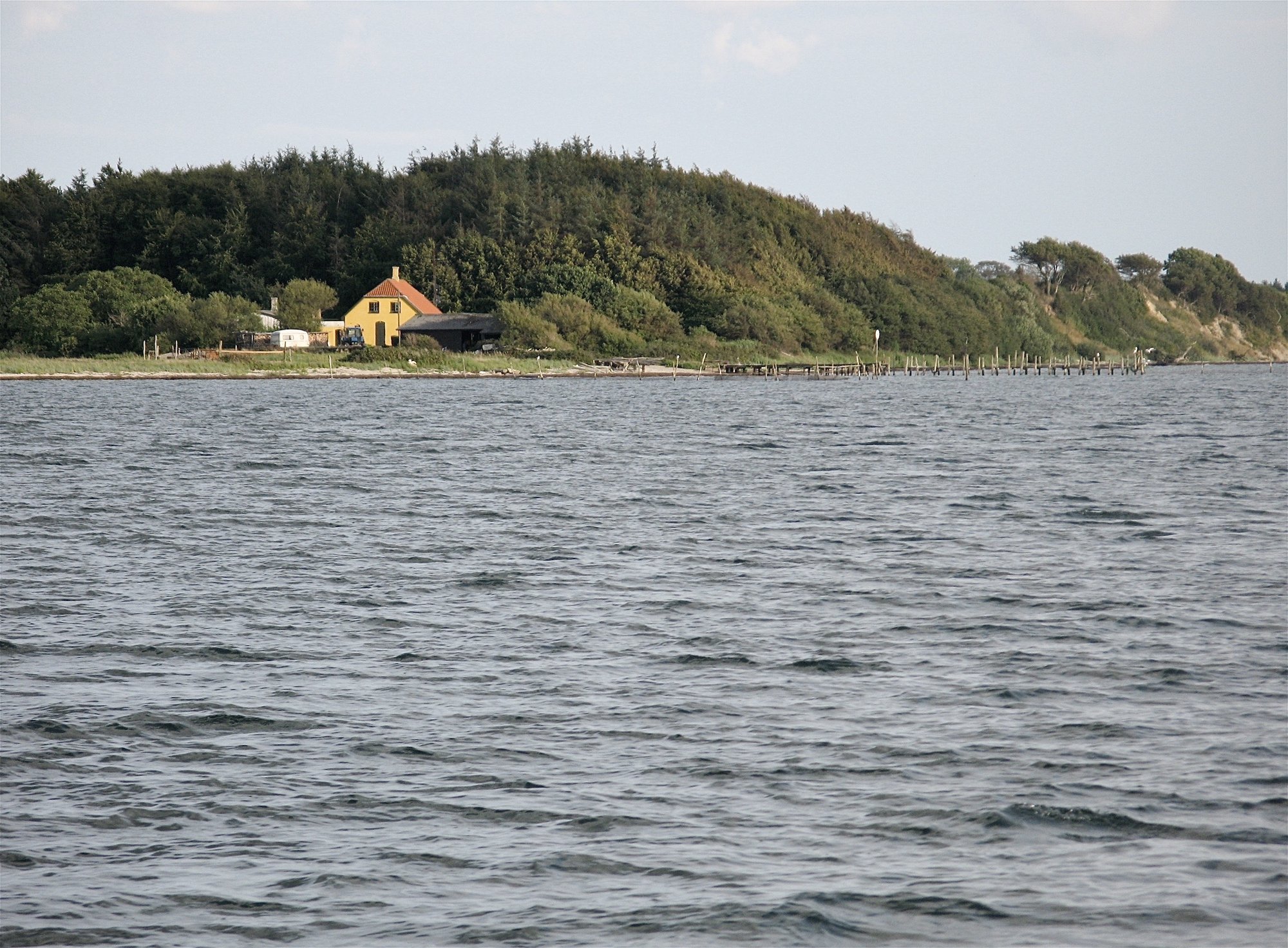 Gulkalket fiskerhus ved stranden på Fønsskov.