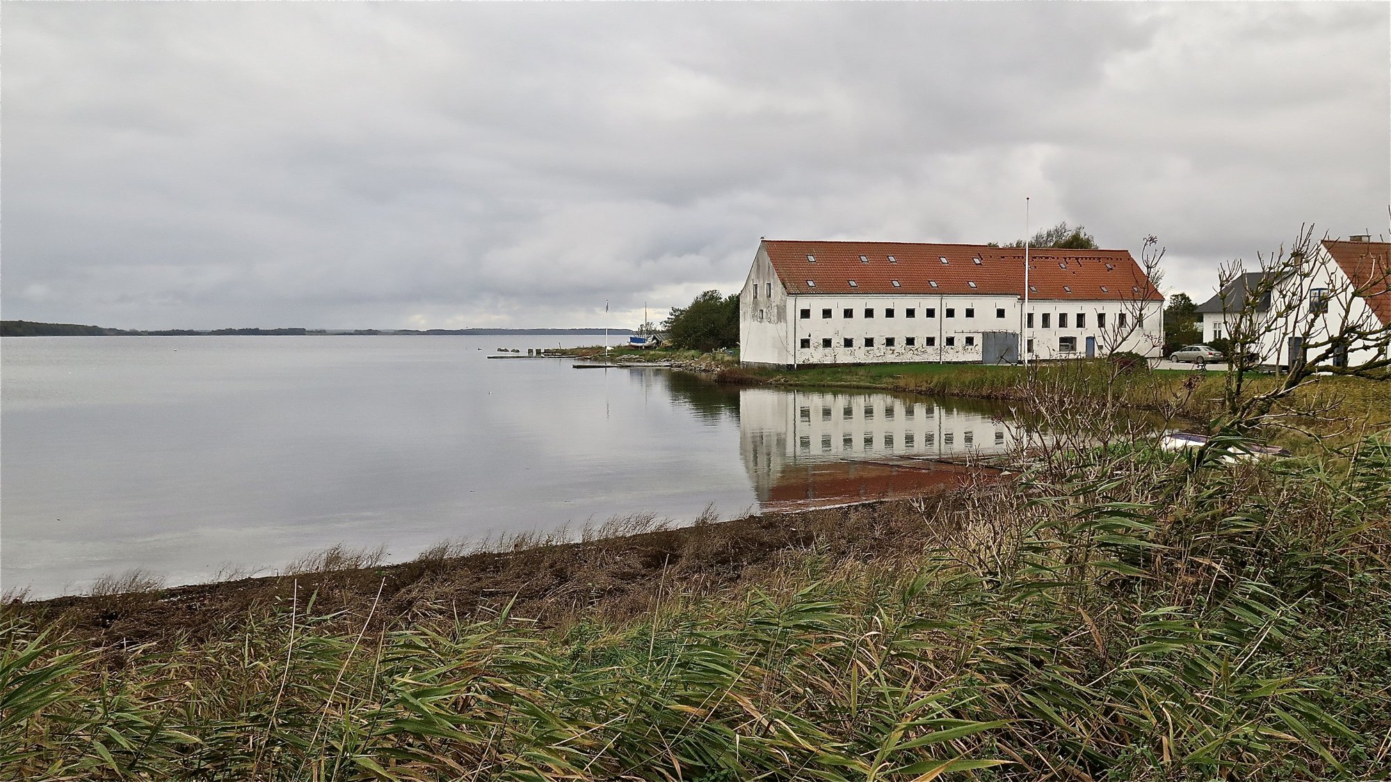 Den store hvide købmandsgård i Ronæs ved Gamborg Fjord.
