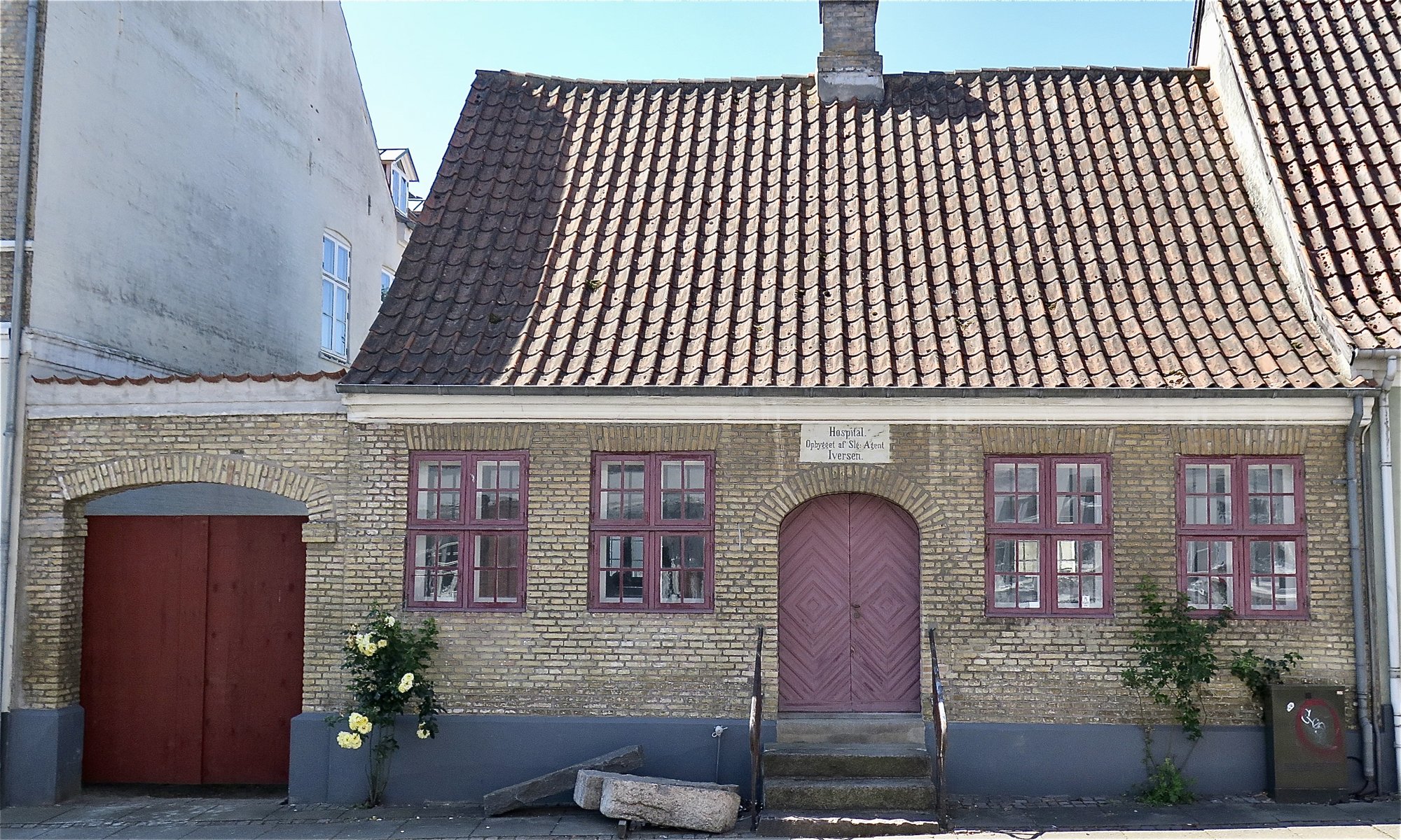 Den historiske teglbygning 'Hospitalet' i Algade 18 i Middelfart med 'Hospital' skrevet over døren.