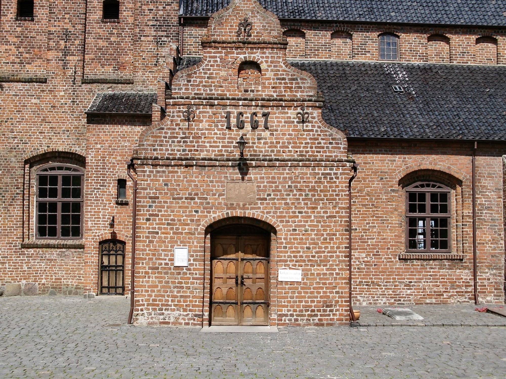 Sandstensrelief af et tremastet skib på Middelfart Kirke med initialerne JHG.